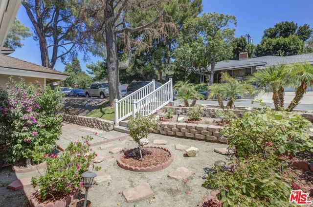 a view of a house with backyard sitting area and garden