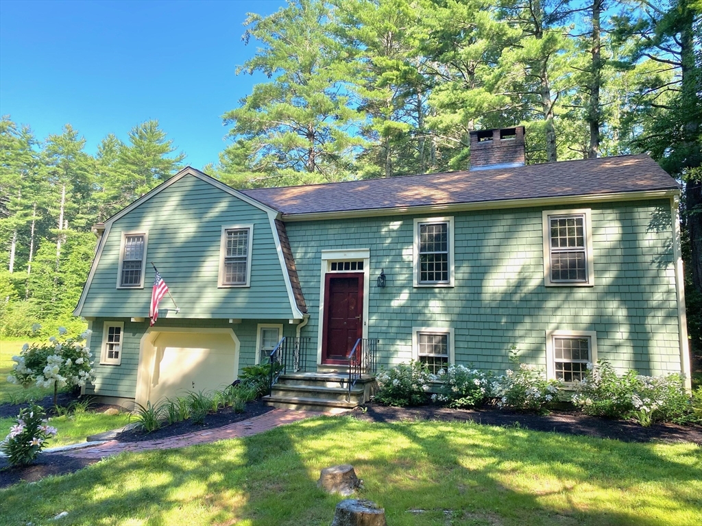 a front view of a house with a yard and potted plants