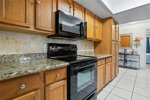 a kitchen with stainless steel appliances granite countertop a stove a sink and a microwave