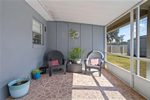 a living room with furniture a flat screen tv and a large window