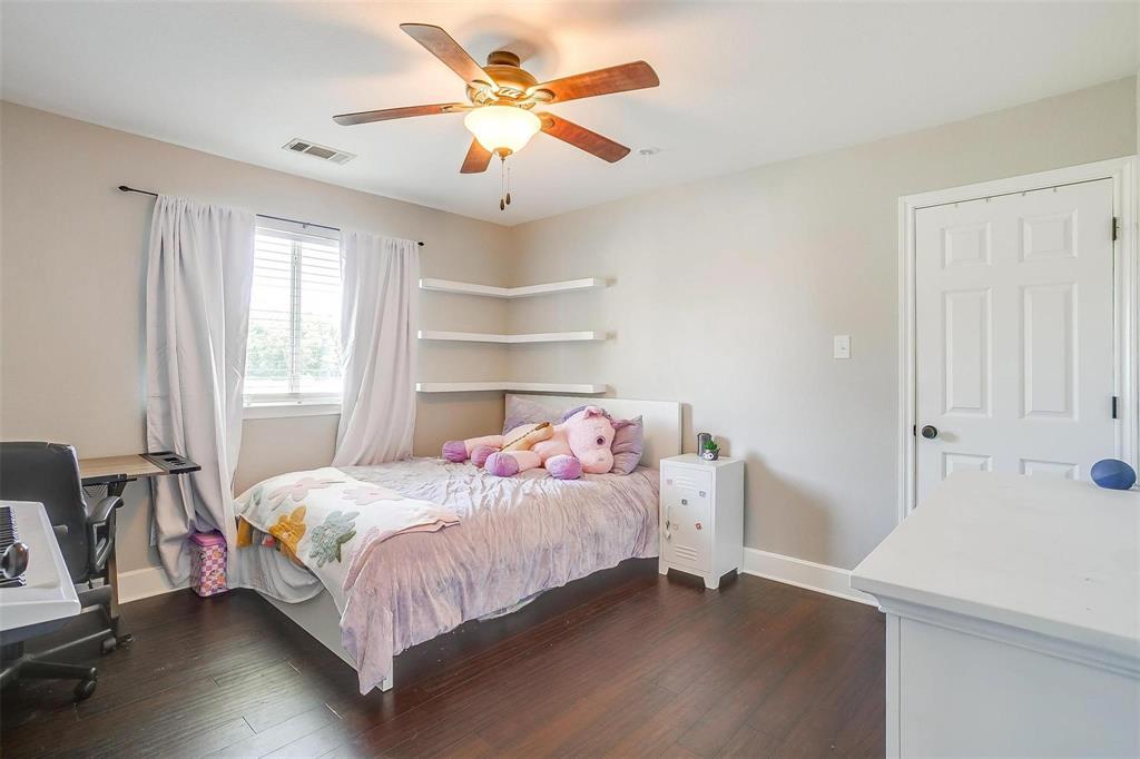 101 Springfield Lane Red Oak, TX 75165 - Photo 30 of 38 a bedroom with a bed and a chandelier