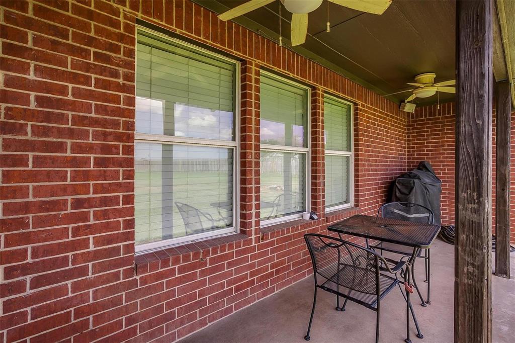 101 Springfield Lane Red Oak, TX 75165 - Photo 33 of 38 a view of a brick house with a chairs and table in the patio