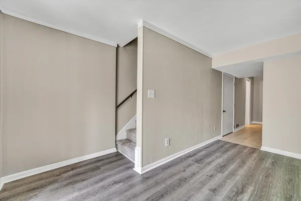 a view of an empty room with a window and a dresser