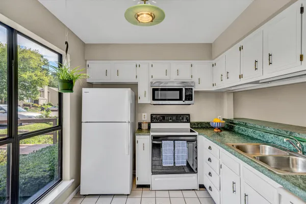 a kitchen with granite countertop white cabinets and white appliances