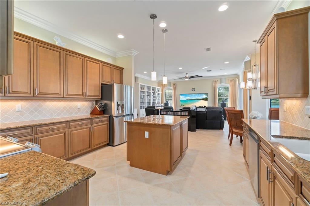 1879 Ivory Cane Point Naples, FL 34119 - Photo 14 of 49 a large kitchen with kitchen island a counter top space a sink stainless steel appliances and cabinets