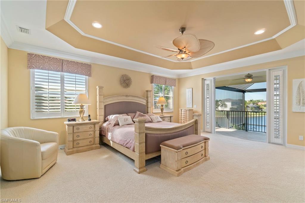 1879 Ivory Cane Point Naples, FL 34119 - Photo 22 of 49 a spacious bedroom with a bed a couch and chandelier