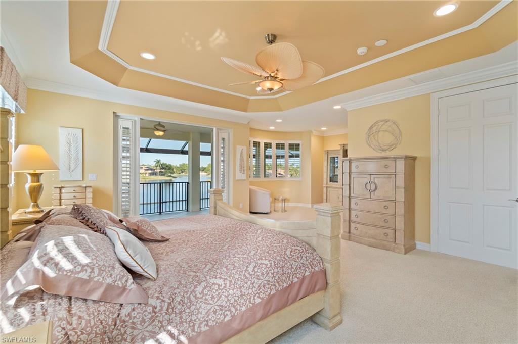1879 Ivory Cane Point Naples, FL 34119 - Photo 24 of 49 a bedroom with a large bed and a chandelier