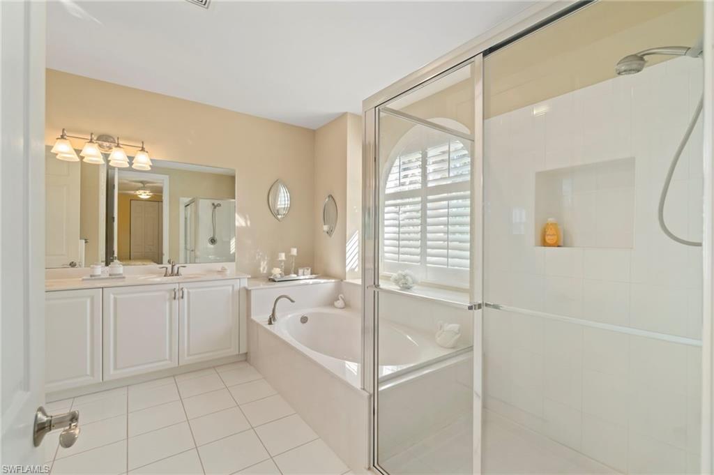 1879 Ivory Cane Point Naples, FL 34119 - Photo 32 of 49 a bathroom with a granite countertop sink a mirror and a bathtub