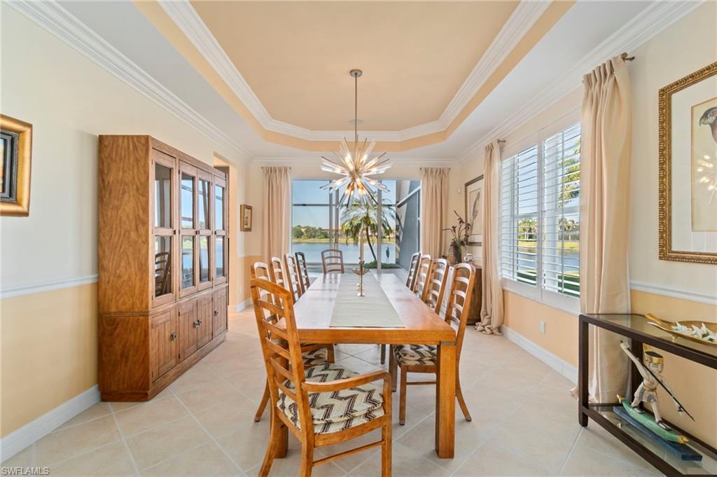 1879 Ivory Cane Point Naples, FL 34119 - Photo 6 of 49 a dining room with furniture a chandelier and wooden floor