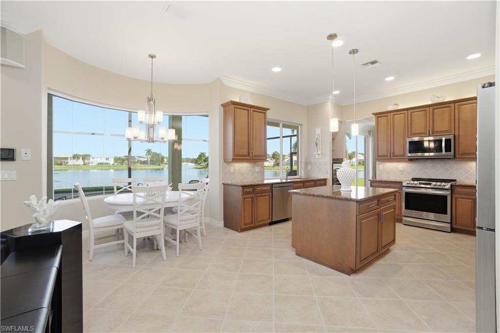 1879 Ivory Cane Point Naples, FL 34119 - Photo 10 of 49 a kitchen with a sink counter top space appliances and a dining table