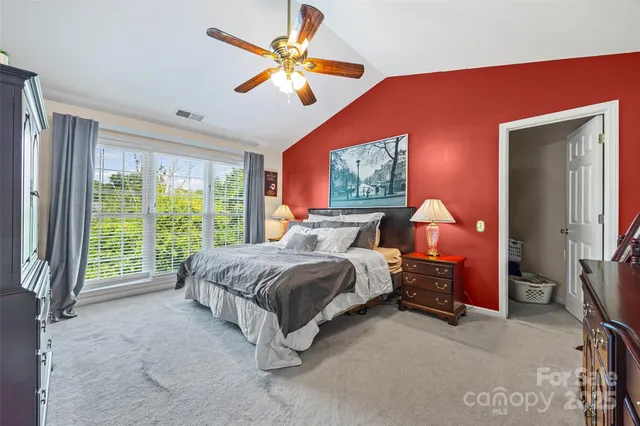 a spacious bedroom with a bed and a chandelier
