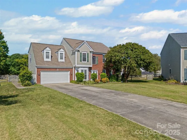 a front view of a house with a yard and trees