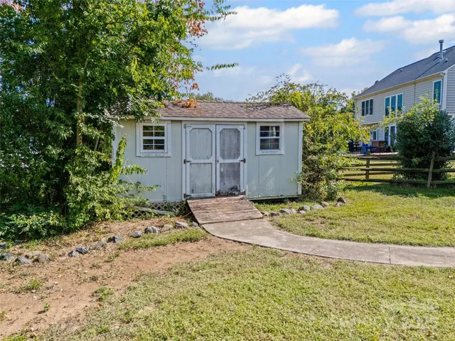 a view of a house with a yard and potted plants