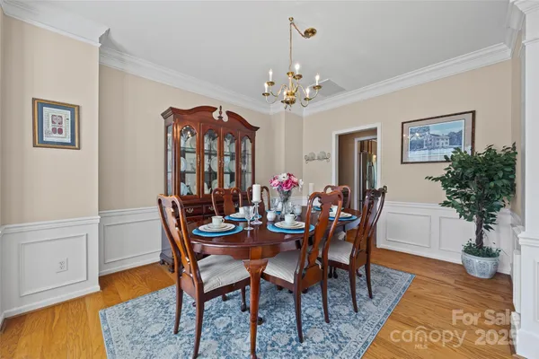 a view of a dining room with furniture a chandelier and wooden floor