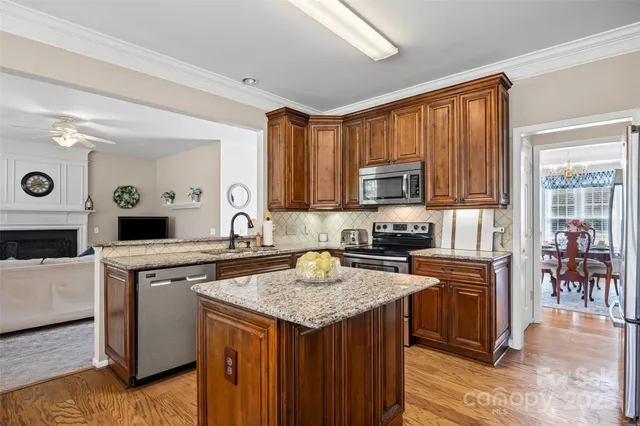 a kitchen with granite countertop wooden cabinets and a stove top oven
