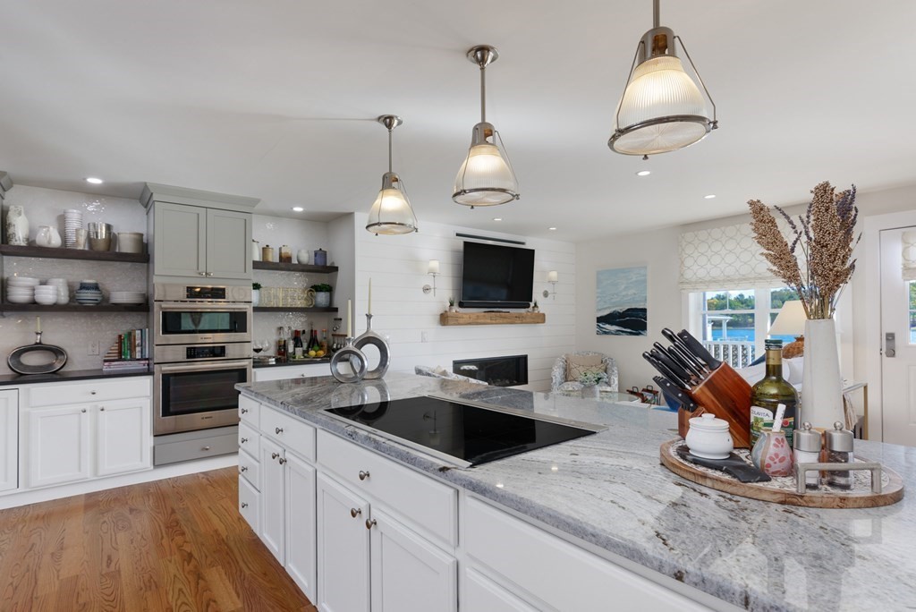 18 Clifton Avenue Hull, MA 02045 - Photo 13 of 39 a kitchen with stainless steel appliances kitchen island granite countertop a sink a stove and a wooden floors