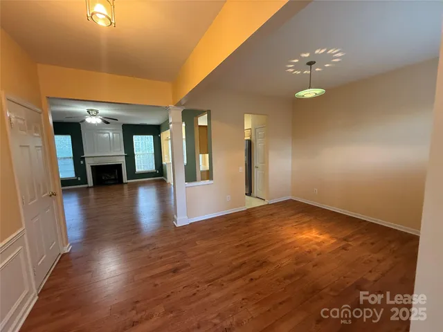 a view of a hallway with wooden floor and a chandelier