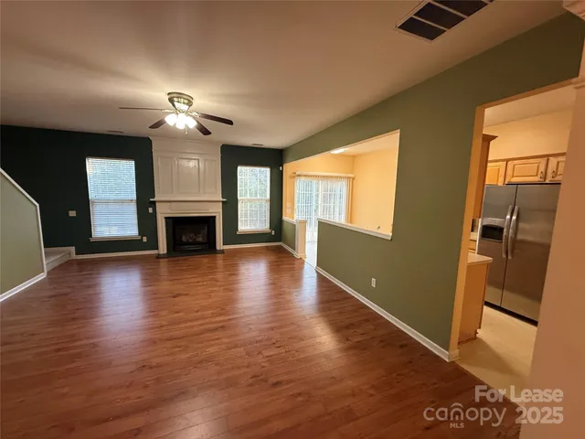 a view of an empty room with a fireplace and a window