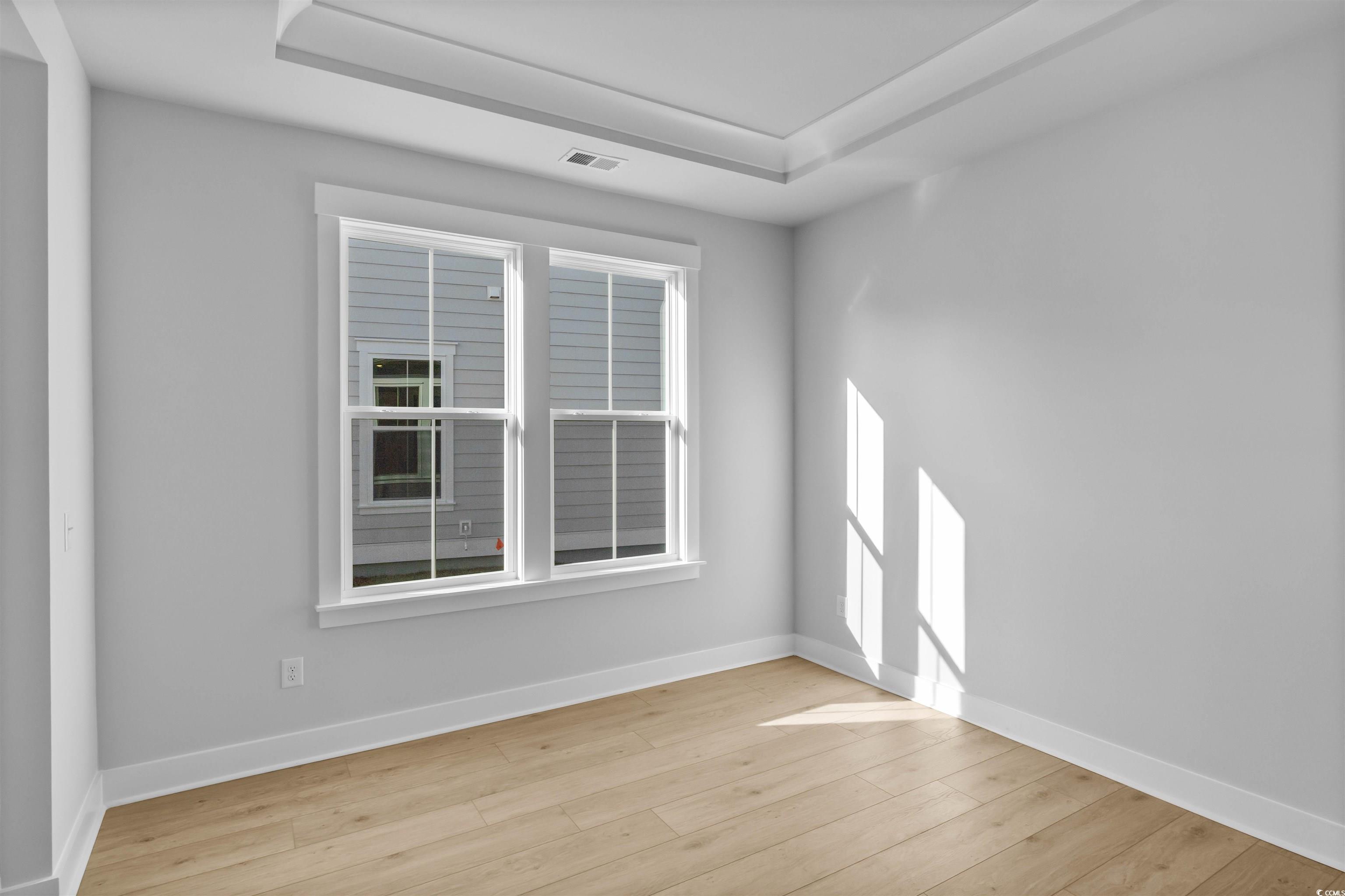 231 Atlantic Breeze Street Myrtle Beach, SC 29572 - Photo 11 of 21 Unfurnished room featuring light wood-style flooring and a raised ceiling