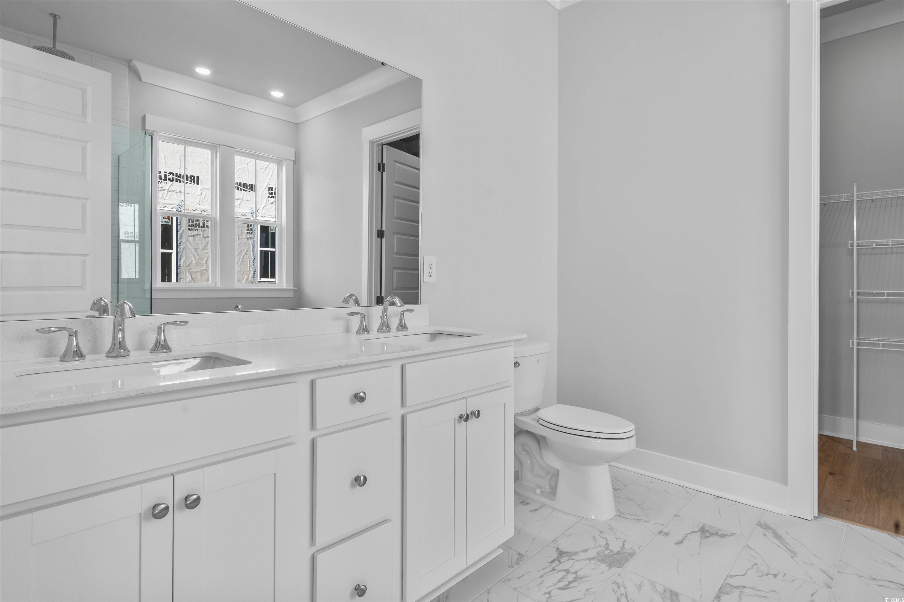 231 Atlantic Breeze Street Myrtle Beach, SC 29572 - Photo 20 of 21 Bathroom with light marble finish floors, double vanity, a shower with shower door, a spacious closet, and recessed lighting