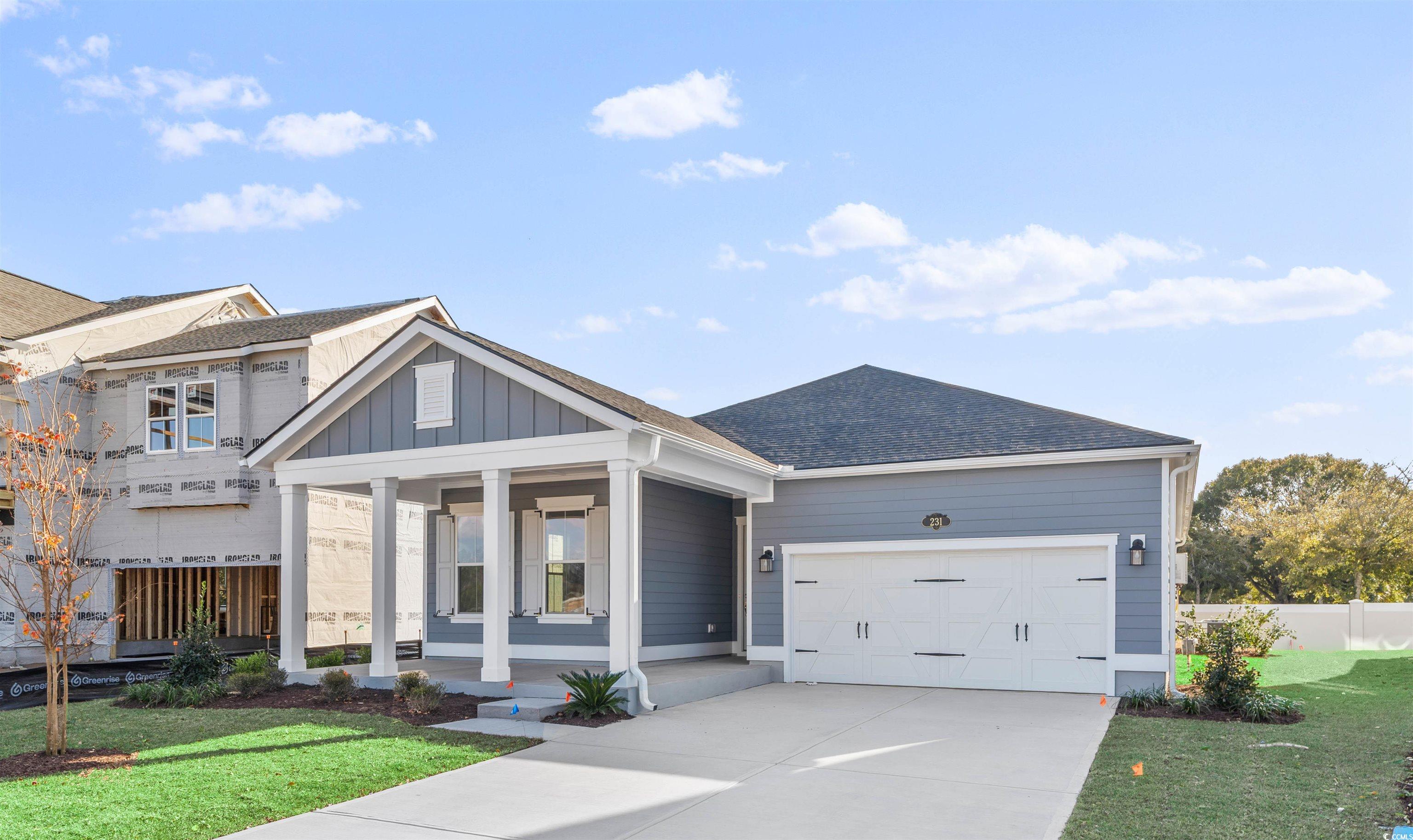 231 Atlantic Breeze Street Myrtle Beach, SC 29572 - Photo 3 of 21 View of front of house featuring board and batten siding, driveway, a shingled roof, a porch, and a garage