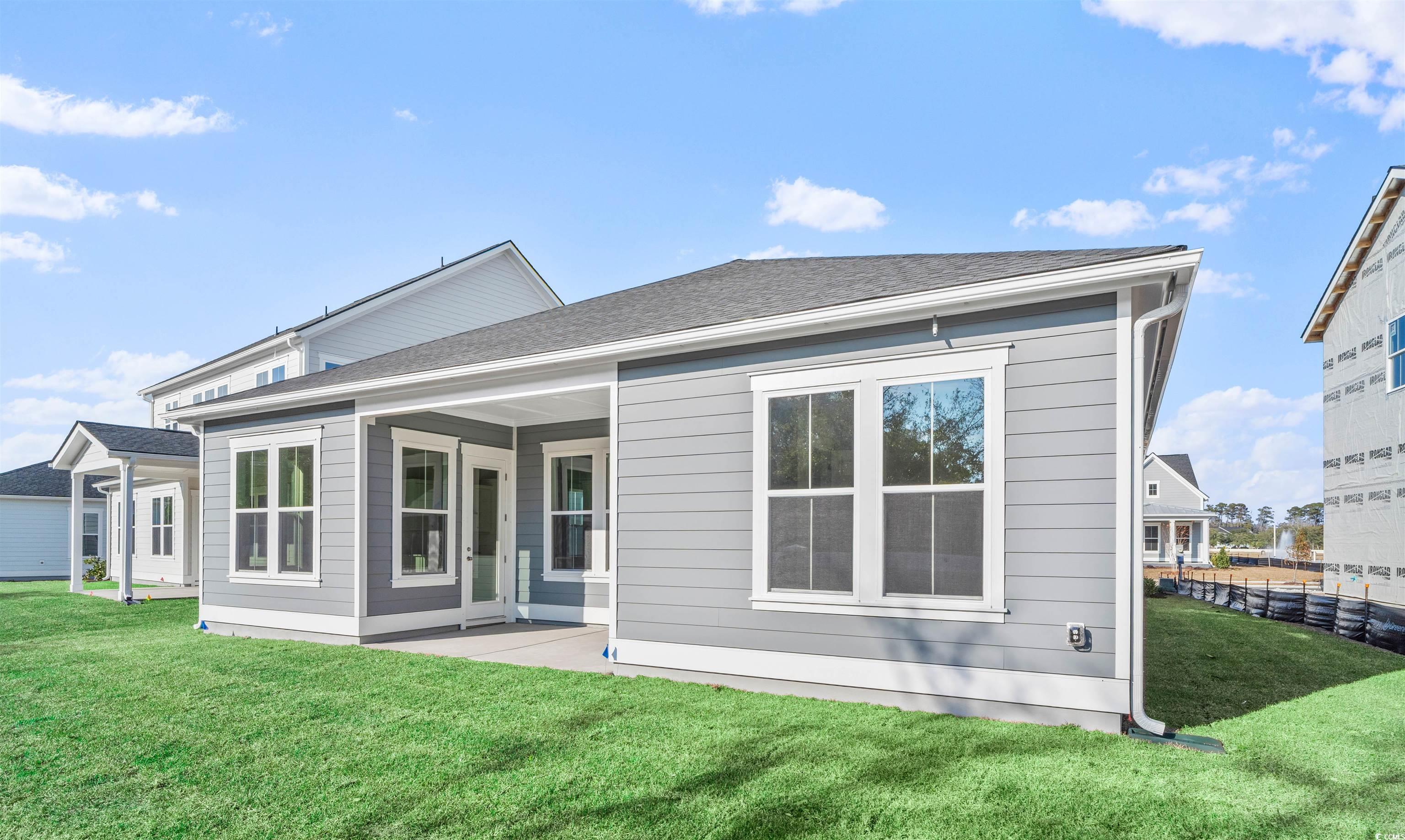 231 Atlantic Breeze Street Myrtle Beach, SC 29572 - Photo 4 of 21 Rear view of house with a patio, a lawn, and roof with shingles
