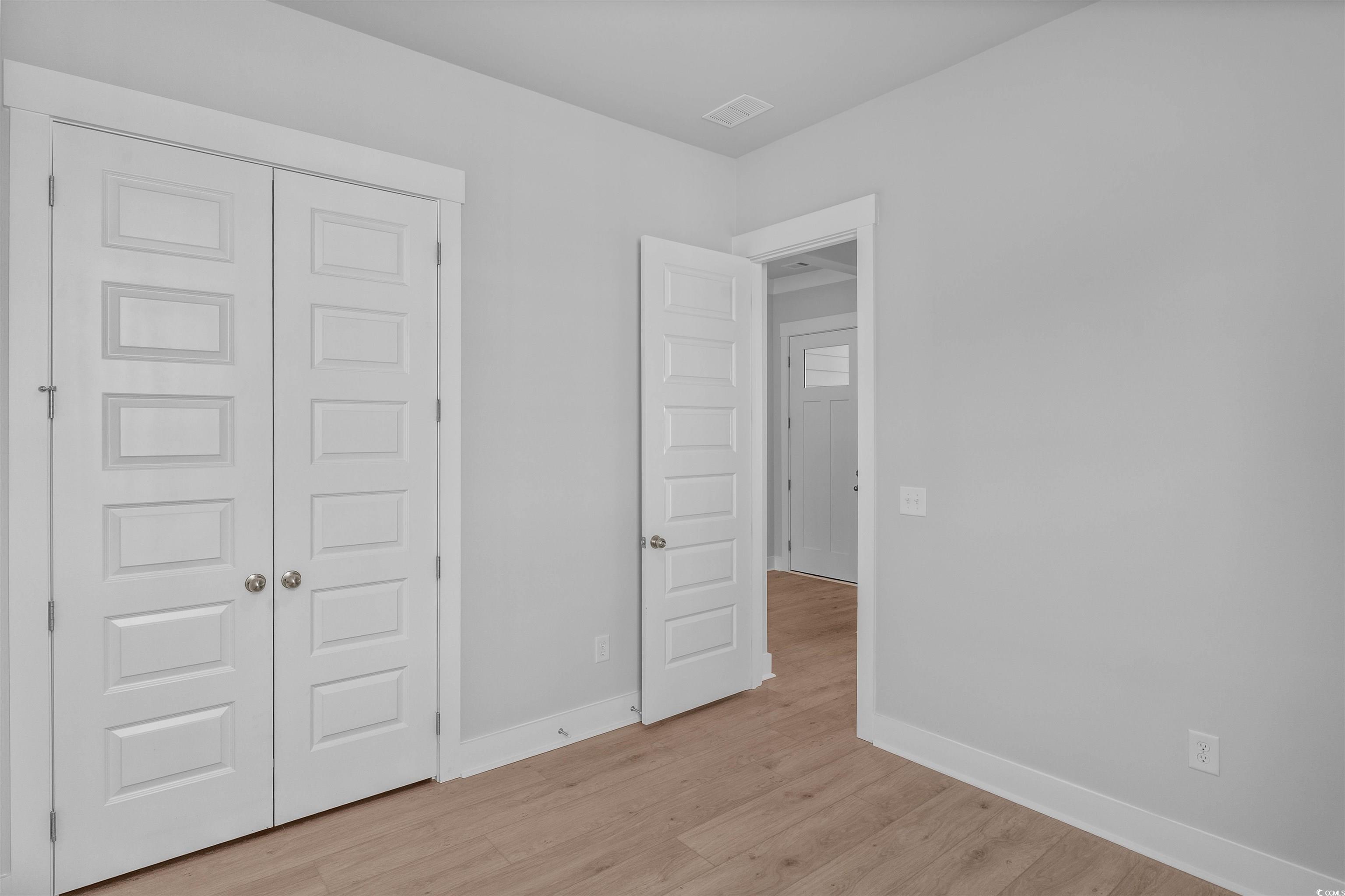 231 Atlantic Breeze Street Myrtle Beach, SC 29572 - Photo 9 of 21 Unfurnished bedroom with light wood-type flooring and a closet