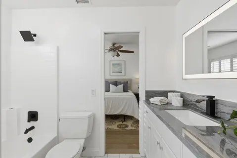 a bathroom with a granite countertop sink and a mirror