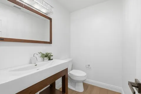 a bathroom with a sink a toilet and mirror