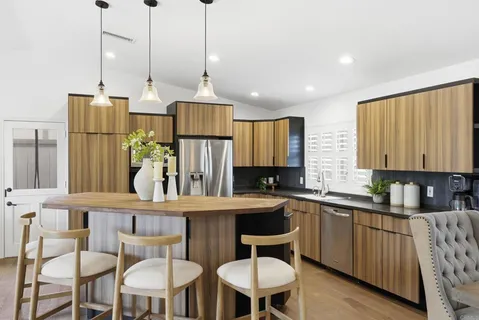 a kitchen that has a table chairs in it and wooden floors