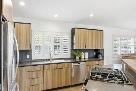 a kitchen with sink a window and cabinets