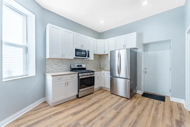 a kitchen with a refrigerator stove and wooden cabinets