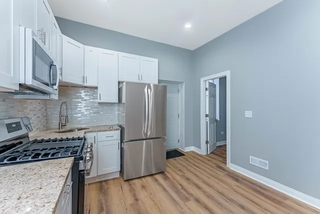 a kitchen with a refrigerator and a stove top oven