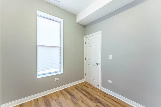 a view of an empty room with closet and a window