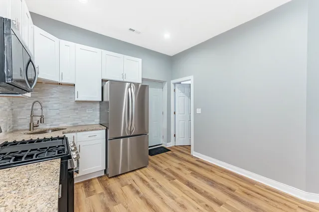 a kitchen with granite countertop a refrigerator stove and sink