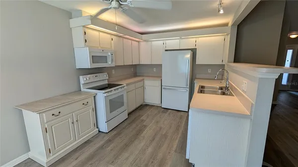 a kitchen with white cabinets and white appliances