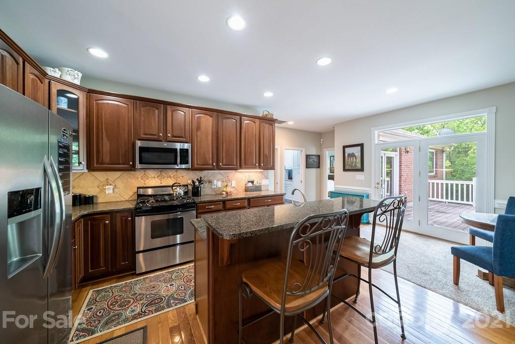 310 Bridle Path Farm Road Cleveland, NC 27013 - Photo 11 of 48 a kitchen with stainless steel appliances granite countertop a stove top oven a sink a dining table and chairs
