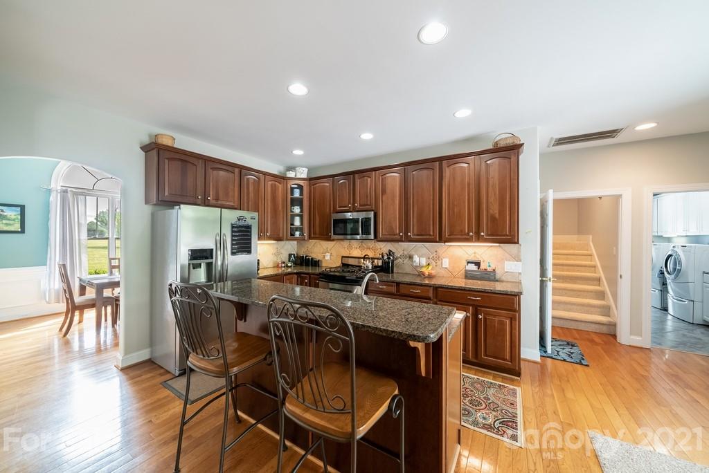 310 Bridle Path Farm Road Cleveland, NC 27013 - Photo 12 of 48 a kitchen with stainless steel appliances kitchen island granite countertop a stove a refrigerator a kitchen island a table and chairs