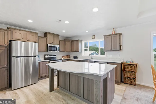 a kitchen with stainless steel appliances granite countertop a refrigerator a sink a stove a microwave and island
