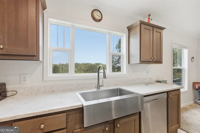 a view with granite countertop a sink a window and cabinets