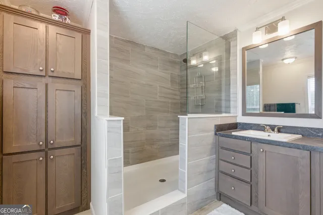 a bathroom with a shower sink and mirror