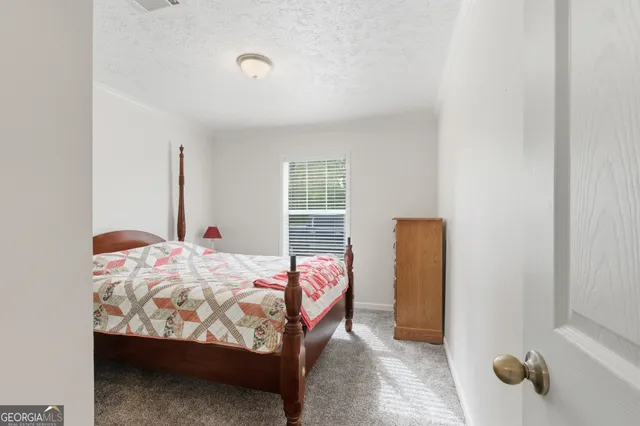 a bed sitting in a bedroom next to a window