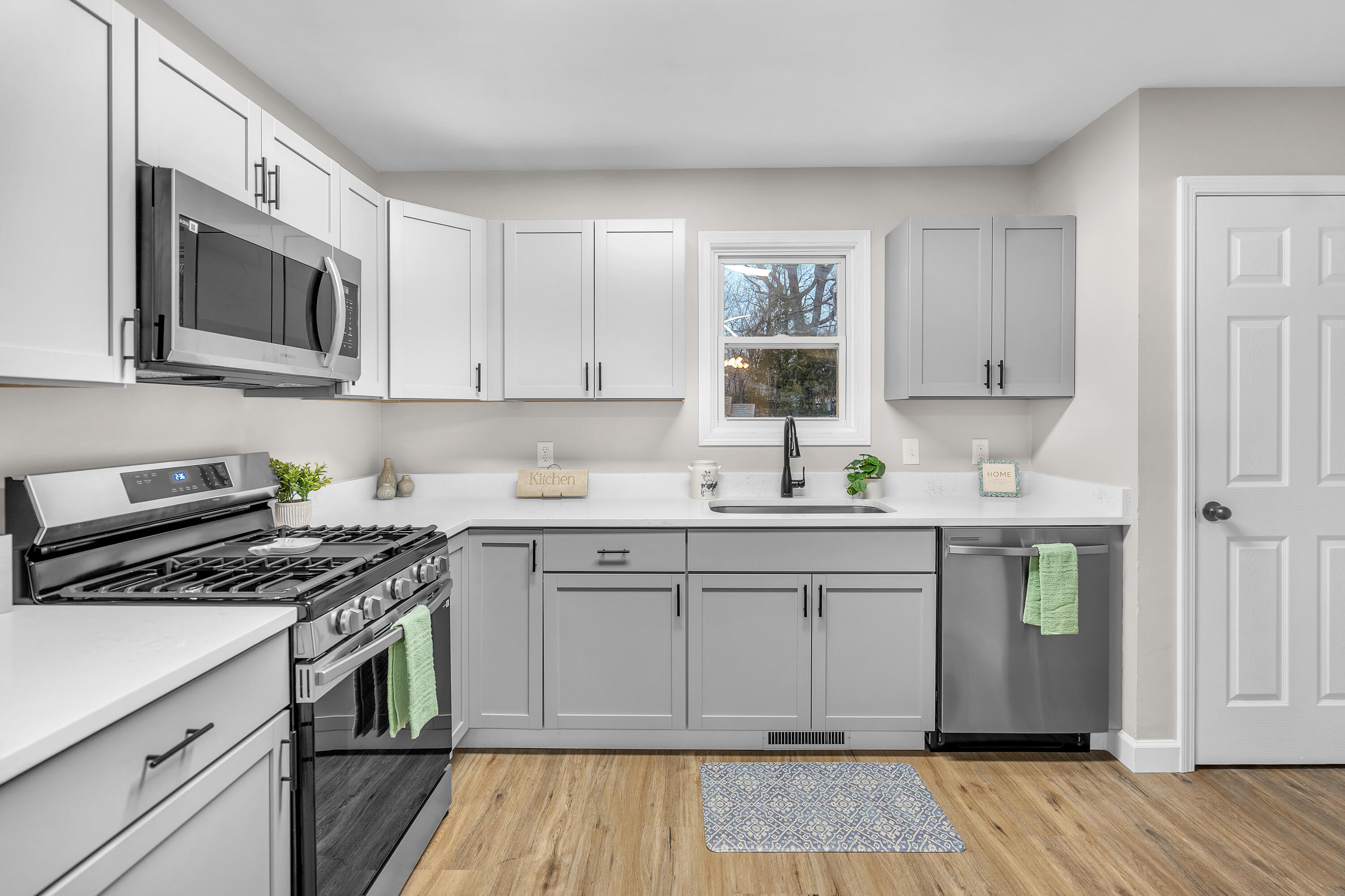 3902 North Explorer Lane Wheatfield, IN 46392 - Photo 7 of 34 a kitchen with granite countertop a sink cabinets stainless steel appliances and wooden floor