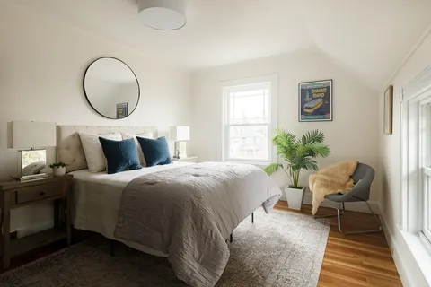 a living room with furniture a potted plant and a window