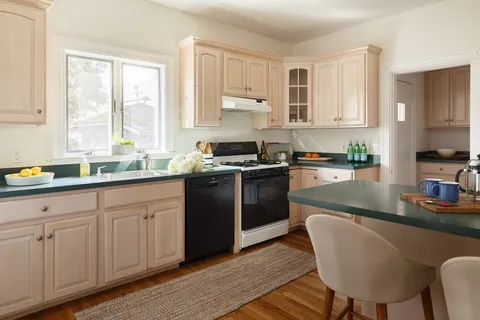 a kitchen with granite countertop a sink stove and cabinets