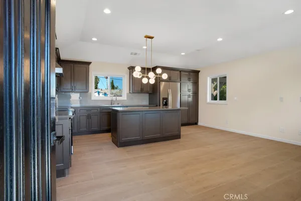 a kitchen with kitchen island a sink stainless steel appliances and cabinets