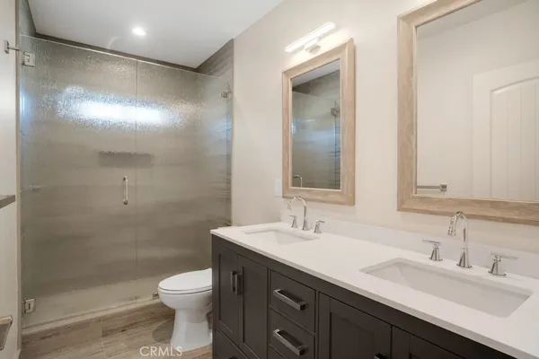 a bathroom with a double vanity sink toilet and a mirror