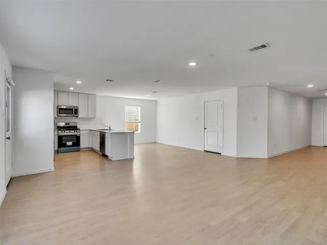 a kitchen with stainless steel appliances a stove a refrigerator a microwave a sink and cabinets