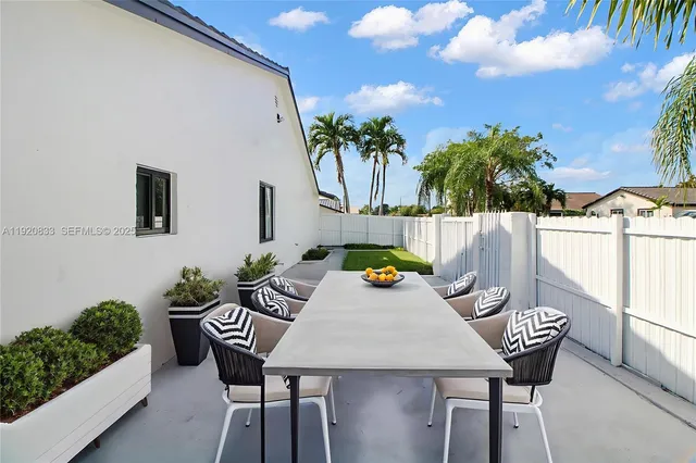 a view of a dinning table and chairs in patio of the house