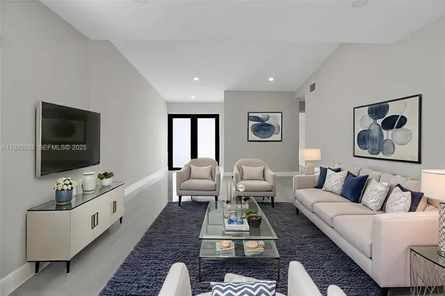 a living room with furniture a flat screen tv and a window